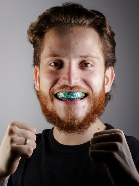 Paciente em pose de luta com placa verde e preta